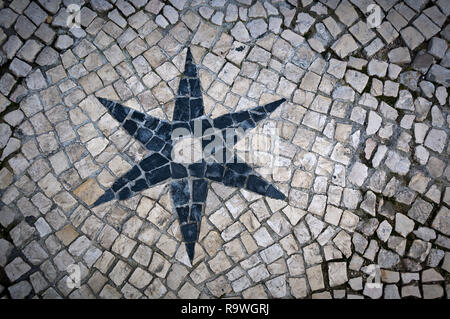 Jouant avec des formes et des motifs différents d'une rue pavée de Lisbonne (Portugal). Étoile à six pointes noir entouré de blanc pavés. Banque D'Images