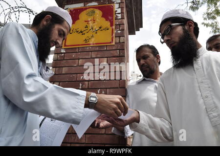 Un homme distribue des dépliants à l'extérieur de la mosquée Rouge à Islamabad, également connu sous le nom de laal masjid avant jummah prières. Banque D'Images