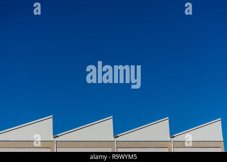 Vue sur les toits d'usine sur journée ensoleillée sur fond bleu Banque D'Images