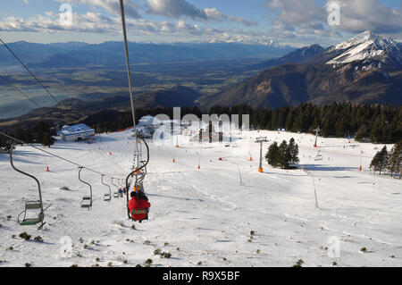 Les gens d'une circonscription à la société Alpine de Krvavec Mountain Ski Resort en Slovénie, vue panoramique des pistes de ski et les Alpes Juliennes en arrière-plan Banque D'Images