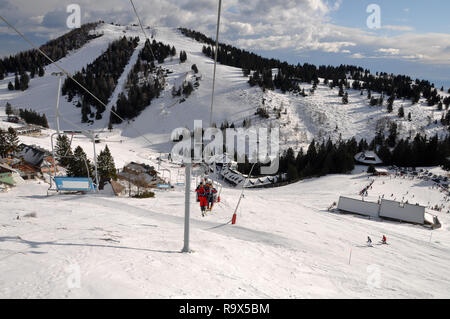 Pistes de Ski alpin Sports d'hiver de Krvavec resort en Slovénie, les gens le ski et équitation un skilift dans la vallée Banque D'Images