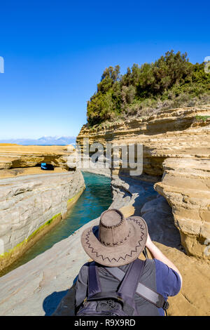 Printemps Ensoleillé vue de Love Canal ou Canal D'Amour avec l'eau bleu de la mer Ionienne et falaises stratifiées à Corfou, l'île de Corfou, Grèce. Retour d'un ma Banque D'Images