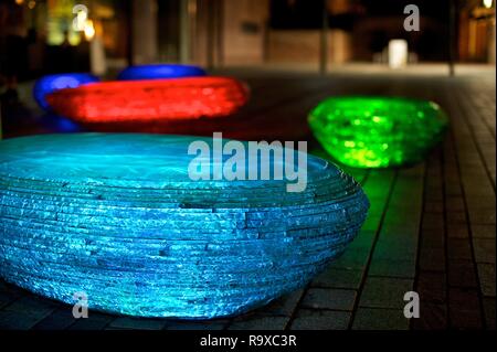 Jeff Bell's collection de verre sièges pebble' par nuit d'un éclairage spécial, intégré dans la structure, les allume progressivement avec un arc-en-ciel seq Banque D'Images