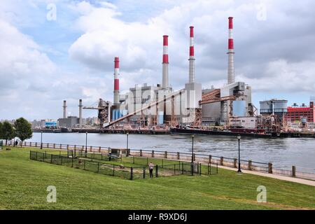 NEW YORK, USA - 3 juillet 2013 : personne marche le chien en face de l'usine de Ravenswood Power Plant à New York. L'usine a été construite en 1965 et est en ce moment o Banque D'Images