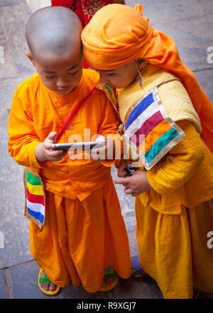 Deux garçons hindoue (4-6) Gai Jatra à la célébration du carnaval à leur téléphone cellulaire à Katmandou, Népal, Asie Banque D'Images