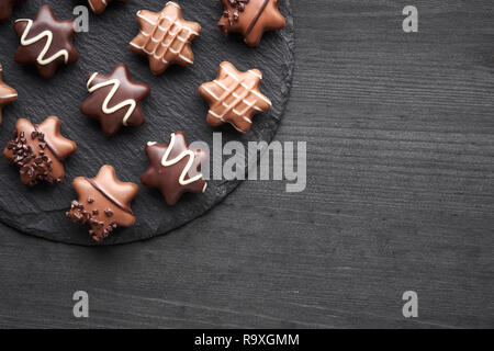 Chocolats en forme d'étoile sur fond texturé noir avec copy-space Banque D'Images