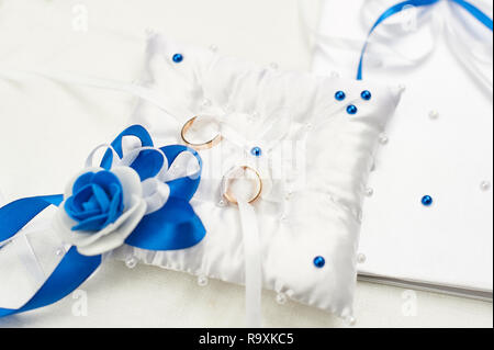 Deux anneaux d'or sur un oreiller blanc pad. Le concept de l'unité et la célébration de mariage Banque D'Images