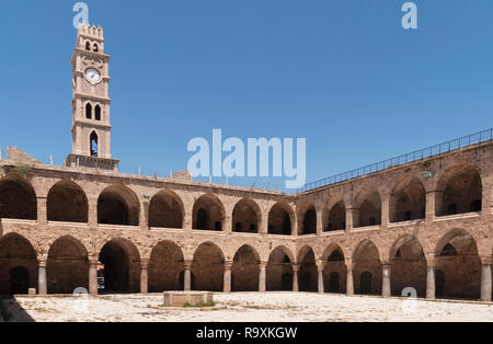 Le caravansérail Khan al umdan à acre akko Israël montrant la cour et la tour de l'horloge avec un ciel bleu clair Banque D'Images