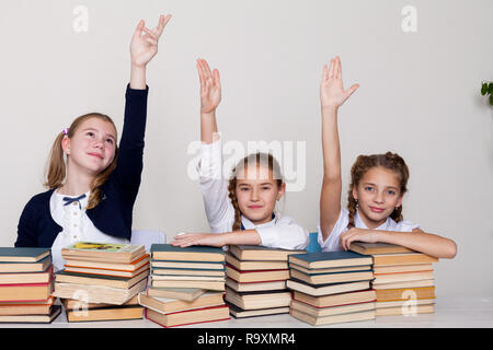 Trois jeunes filles à l'école dans la classe pour savoir livres Banque D'Images