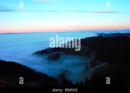 Le brouillard rampant derrière les collines. Vue du Bantiger près de Berne à un jour d'hiver brumeux. Banque D'Images