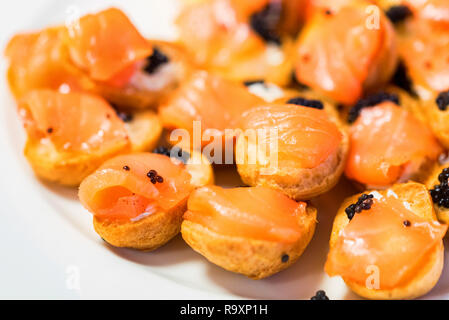 Close up fresh tasty profiterolies avec du saumon et caviar noir Banque D'Images