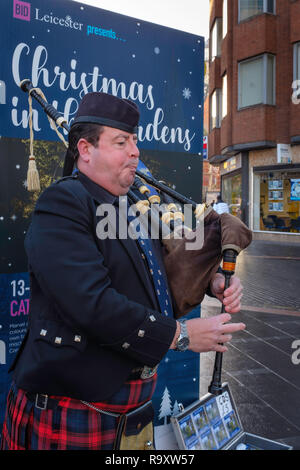 Un cornemuseur soliste de la rue dans le centre-ville de Leicester. Banque D'Images