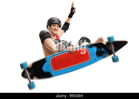 Jeune femme avec un saut skater longboard isolé sur fond blanc Banque D'Images