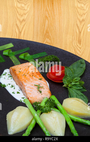 Filet de saumon frit délicieux assaisonnements sur plancher en bois. Pavé de saumon cuit avec des pommes de terre à l'ail poivre citron huile d'olive cuillère. L'espace pour te Banque D'Images