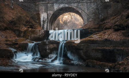 Pont de pierre sous une cascade dans la montagne des Rhodopes près de Sitovo village, Bulgarie, Europe, la photographie d'hiver avec de la glace sur les rochers Banque D'Images