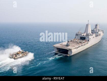 Un débarquement de la Marine américaine, d'un coussin d'air élevées derrière la Marine américaine San Antonio-classe de transport amphibie USS dock Mouillage au cours d'exercices de coopération avec la marine indienne destroyer INS Rajput, le 26 décembre 2018 dans l'Océan Indien. Banque D'Images