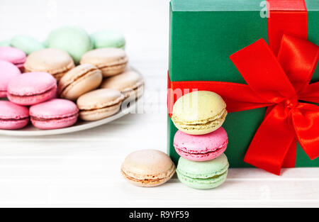 Colorful macarons français près de la boîte de Noël sur fond blanc Banque D'Images