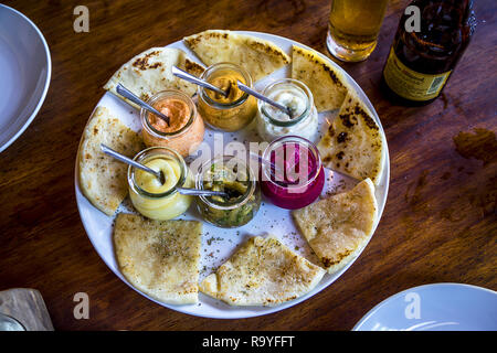 Assiette de pains plats et choix de l'humus dans les bocaux. Banque D'Images