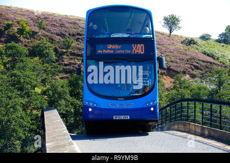 Le Yorkshire Coastliner X40 service de bus autour de manoeuvres un étroit pont courbé à Goathland dans Yorkshire du Nord. Banque D'Images