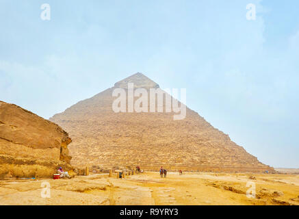 GIZA, EGYPTE - le 20 décembre 2017 : l'ancien vendeur de bédouins de boissons et de collations dans le site archéologique de Gizeh se trouve à la rock de côté de la Grande Pyrami Banque D'Images