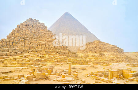 La belle vue sur le reste des petites pyramides des reines et l'énorme pyramide de Chéops sur l'arrière-plan, Giza, Egypte complexes Banque D'Images