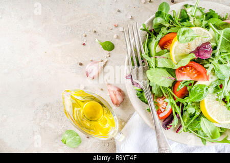 Detox de source fraîche salade mélange avec des légumes (concombre, citron, tomates, roquette, jeunes épinards), et sur la lumière de l'ardoise, de la pierre ou du béton. Top v Banque D'Images