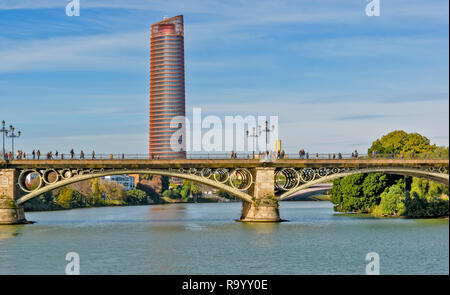 Espagne Séville Séville OU LA TOUR CAJASOL ET PERSONNES TRAVERSANT TRIANA PONT SUR LE GUADALQUIVIR Banque D'Images