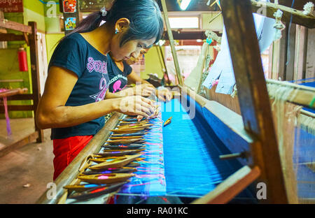 MANDALAY, MYANMAR - février 21, 2018 : Les travailleurs de l'atelier de tissage de créer le schéma complexe de la soie, assis à l'artisanat, le févr. Banque D'Images