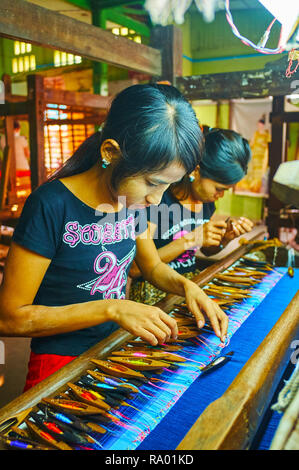 MANDALAY, MYANMAR - février 21, 2018 : les artisans travailler avec des fils de soie colorés à l'artisanat, le 21 février dans la région de Mandalay. Banque D'Images