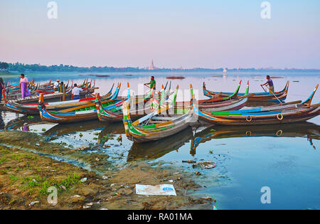 AMARAPURA, MYANMAR - février 21, 2018 : Le canot en bois coloré weit les touristes à port sur le lac Taungthaman et offre le coucher du soleil voyage à U Bein Brid Banque D'Images