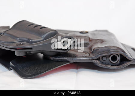 Deux armes de poing, un revolver Magnum 357 d'argent au-dessus d'un pistolet 9 mm noir sur fond blanc. Les deux étuis en noir Banque D'Images