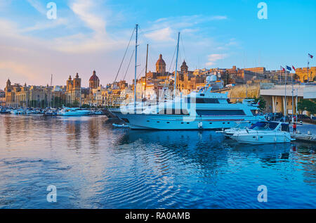Les yachts de luxe dans le port de Birgu avec vue sur des édifices historiques et églises' domes sur l'arrière-plan, Malte. Banque D'Images