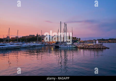 Les chantiers avec yachts amarrés au port de plaisance, Msida soir le ciel crépusculaire violet se reflète sur la surface de l'eau, Malte. Banque D'Images