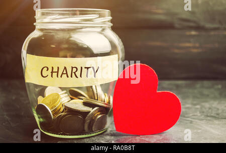 Bocal en verre avec les paroles de charité et le coeur. Le concept d'accumuler de l'argent pour les dons. L'épargne. Médecine sociale de l'aide de bénévoles. Charitab Banque D'Images