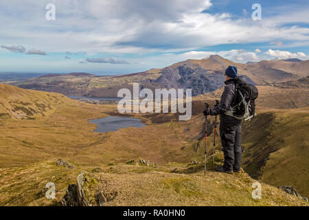 Une seule femme à tout randonneur Llyn (LAC) Dwythwch vers la ville de Llanberis dans le Nord du Pays de Galles, Elider Fawr derrière. Banque D'Images