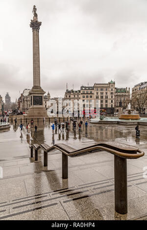 Trafalgar Square, Londres, Angleterre. les touristes à l'abri des pluies d'avril sous les parapluies, avec la Colonne Nelson de l'arrière-plan. Banque D'Images