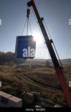 Le camion-grue transporte blocs au chantier de pâtés dans l'air contre le ciel 2018 Banque D'Images