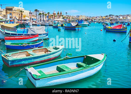 MARSAXLOKK, MALTE - le 18 juin 2018 : à pied de la promenade du bord de mer le long de la pittoresque luzzu bateaux touristiques et restaurants de la région côtière de voisinage reso Banque D'Images