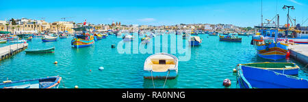 MARSAXLOKK, MALTE - le 18 juin 2018 : Panorama du port avec des centaines de bateaux amarrés et les chalutiers côtiers avec les quartiers de la villa Banque D'Images