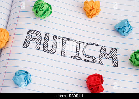 L'autisme. Troubles du spectre autistique. Mot autisme sur feuille portable avec quelques boules de papier froissé coloré sur elle. Close up. Banque D'Images