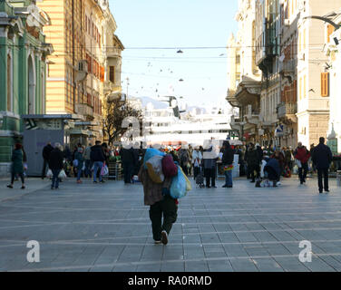 Rijeka, Croatie, 29 décembre 2018. Marché d'une ville pleine de gens et l'homme avec les sacs sur le dos Banque D'Images