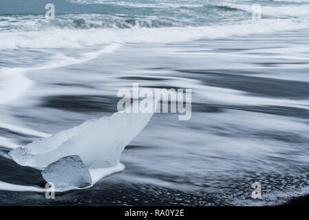 Des morceaux de glace brisée d'un glacier sur Diamond Beach, une plage de sable noir en Islande Banque D'Images