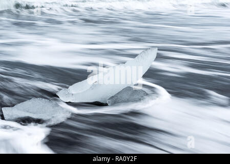 Des morceaux de glace brisée d'un glacier sur Diamond Beach, une plage de sable noir en Islande Banque D'Images