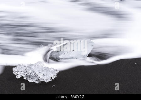 Des morceaux de glace brisée d'un glacier sur Diamond Beach, une plage de sable noir en Islande Banque D'Images