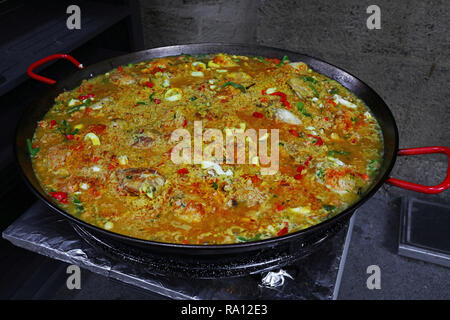 Close up la cuisson de la paella mixte Valencienne traditionnelle espagnole avec du poulet, des fruits de mer et légumes dans grande poêle, high angle view Banque D'Images