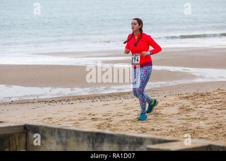 Bournemouth, Dorset, UK. Le 30 décembre 2018. Les participants prennent part à la plage de la race, de la race la marée, une plage à marée basse le long de la magnifique côte de la plage de Bournemouth vers la plage de Sandbanks. Porteur exécuter le 5k ou 10k race le long du littoral et sur les épis avant la marée monte - bon exercice après les excès de Noël ! Credit : Carolyn Jenkins/Alamy Live News Banque D'Images