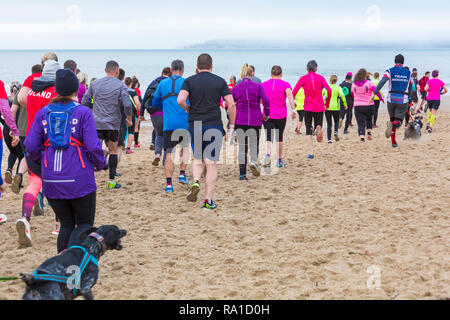 Bournemouth, Dorset, UK. Le 30 décembre 2018. Les participants prennent part à la plage de la race, de la race la marée, une plage à marée basse le long de la magnifique côte de la plage de Bournemouth vers la plage de Sandbanks. Porteur exécuter le 5k ou 10k race le long du littoral et sur les épis avant la marée monte - bon exercice après les excès de Noël ! Credit : Carolyn Jenkins/Alamy Live News Banque D'Images