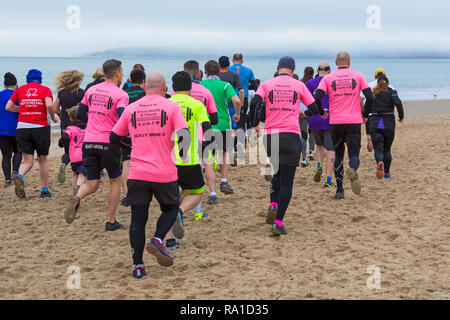 Bournemouth, Dorset, UK. Le 30 décembre 2018. Les participants prennent part à la plage de la race, de la race la marée, une plage à marée basse le long de la magnifique côte de la plage de Bournemouth vers la plage de Sandbanks. Porteur exécuter le 5k ou 10k race le long du littoral et sur les épis avant la marée monte - bon exercice après les excès de Noël ! Credit : Carolyn Jenkins/Alamy Live News Banque D'Images