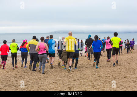 Bournemouth, Dorset, UK. Le 30 décembre 2018. Les participants prennent part à la plage de la race, de la race la marée, une plage à marée basse le long de la magnifique côte de la plage de Bournemouth vers la plage de Sandbanks. Porteur exécuter le 5k ou 10k race le long du littoral et sur les épis avant la marée monte - bon exercice après les excès de Noël ! Credit : Carolyn Jenkins/Alamy Live News Banque D'Images