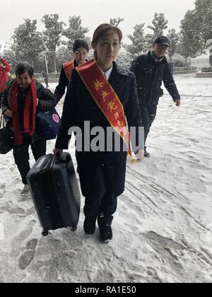 Nanchang, province de Jiangxi en Chine. Dec 30, 2018. Un bénévole aide à transporter les bagages d'un passager dans la neige de Nanchang Railway Station West à Nanchang, capitale de la province de l'est de la Chine, 30 décembre 2018. Credit : Chanson/Xinhua/Alamy Zhenping Live News Banque D'Images